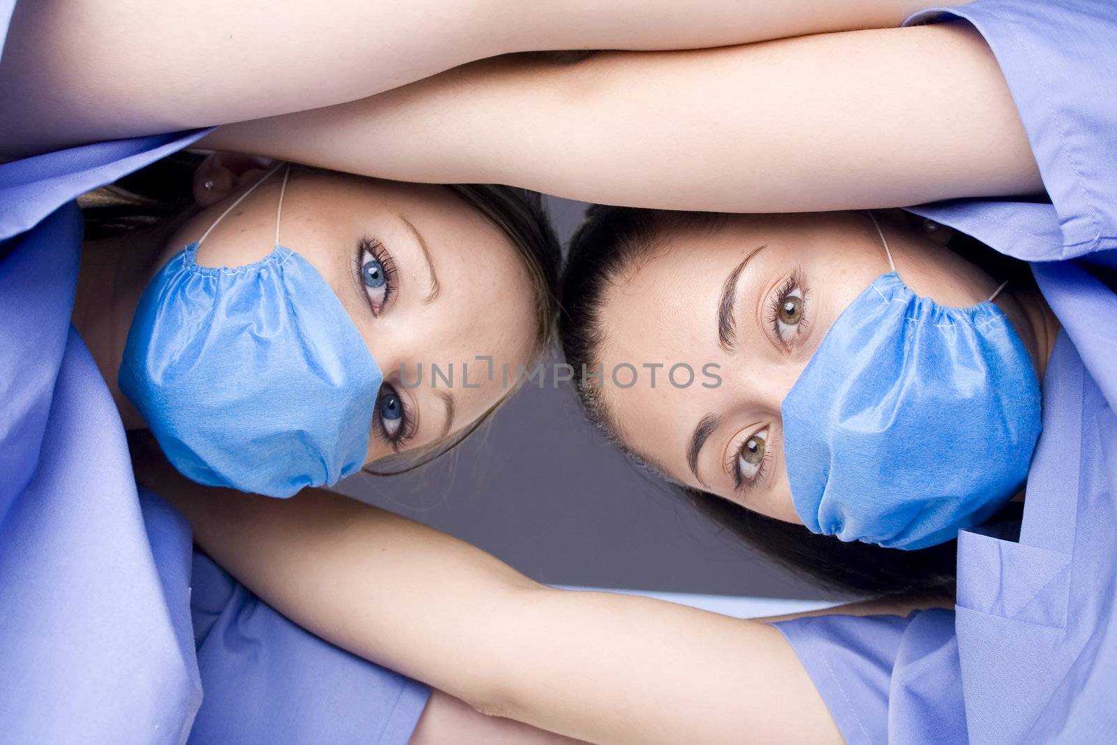 Two nurses huddled together looking down