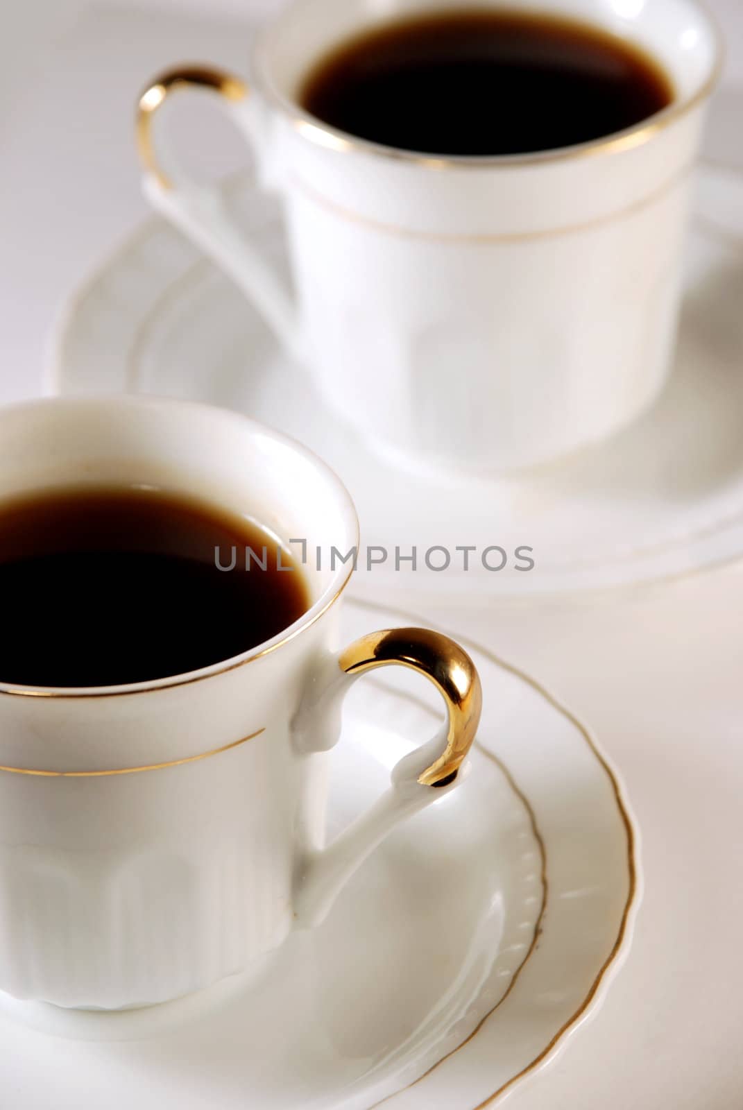 In the photo two white porcelain cups with coffee