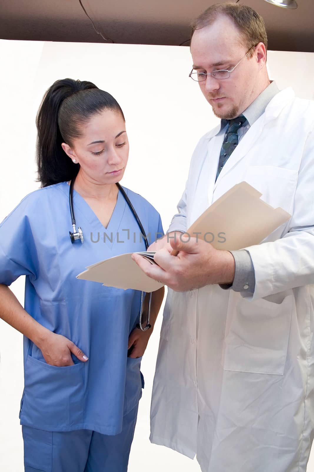 Doctor and nurse reading over notes in file