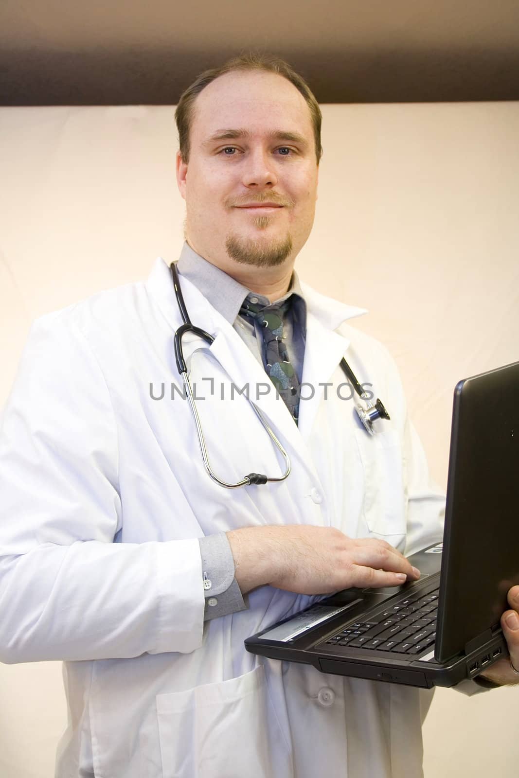 Young doctor with laptop smiling