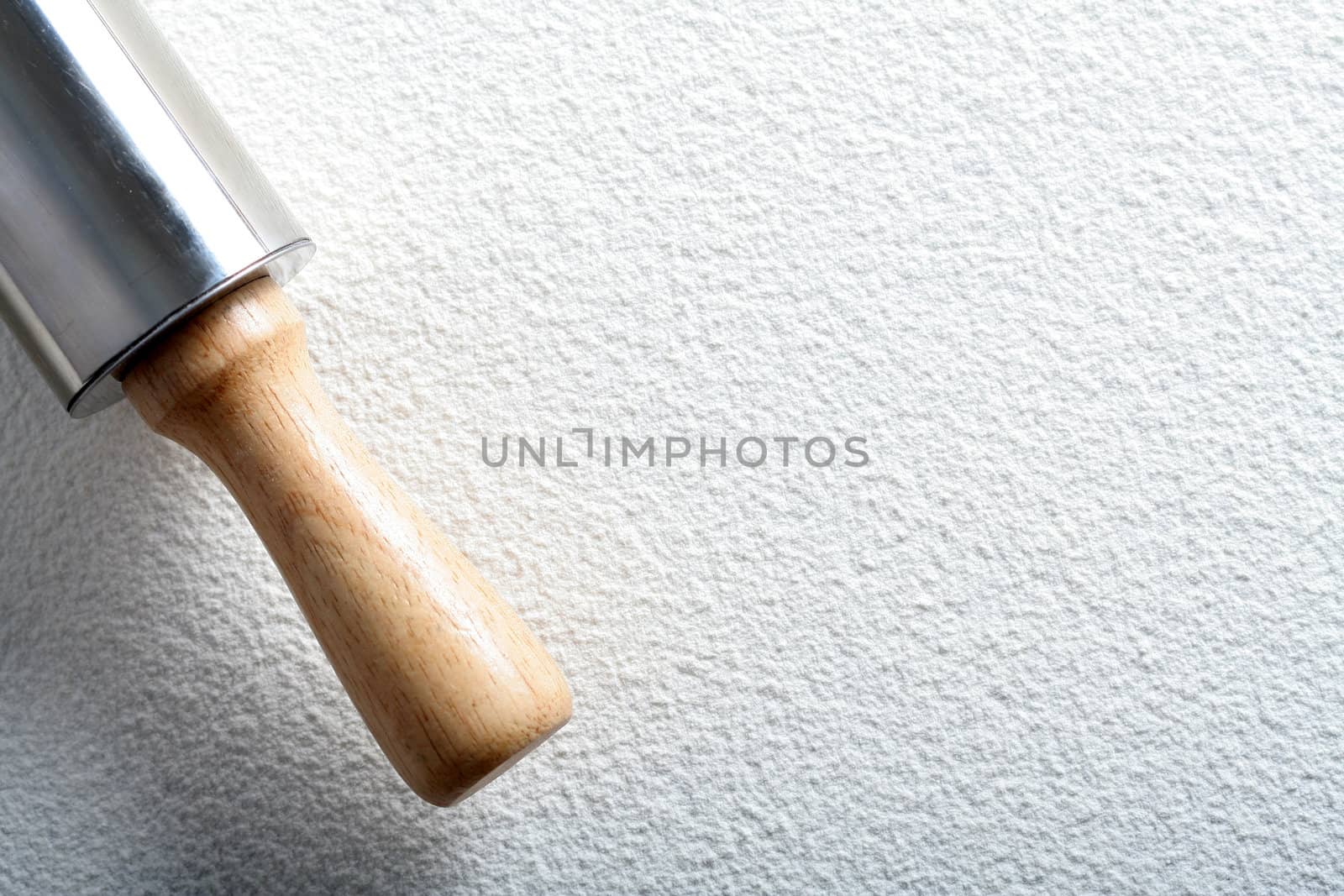 Rolling pin on wheat flour, background