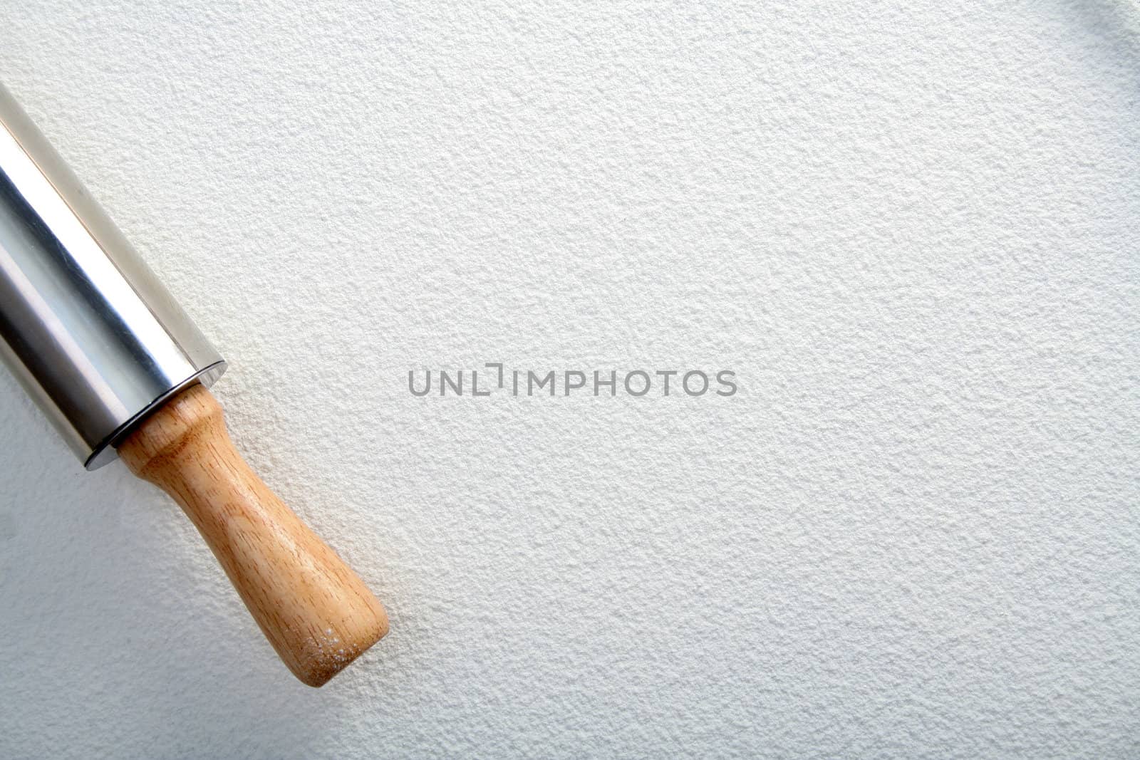 Rolling pin on wheat flour, background