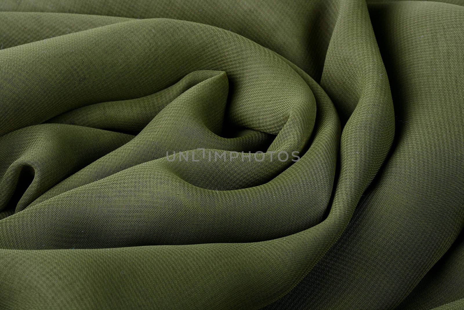 Darkly green fabric as a background for design works.