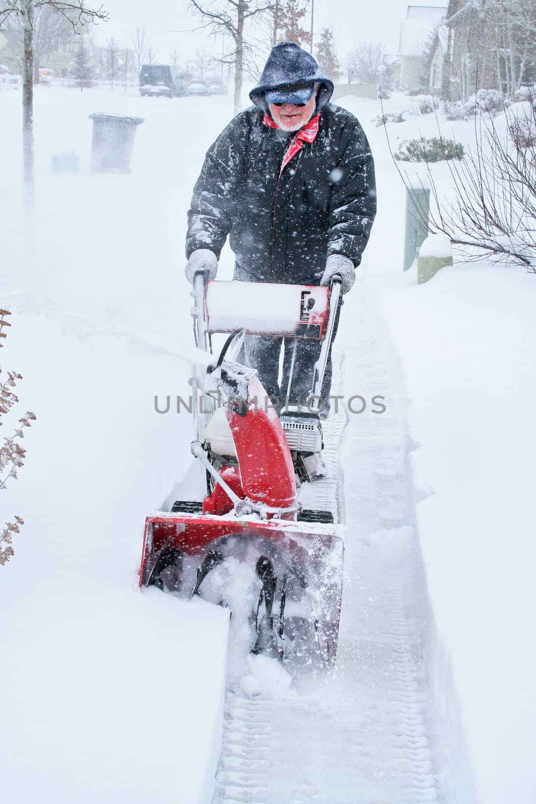 Man snow blowing during storm