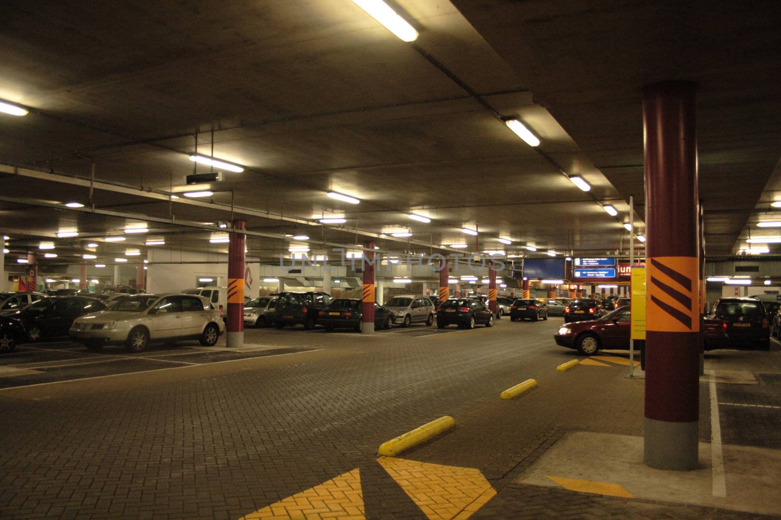 Interior of undergrond parking garage at night with cars