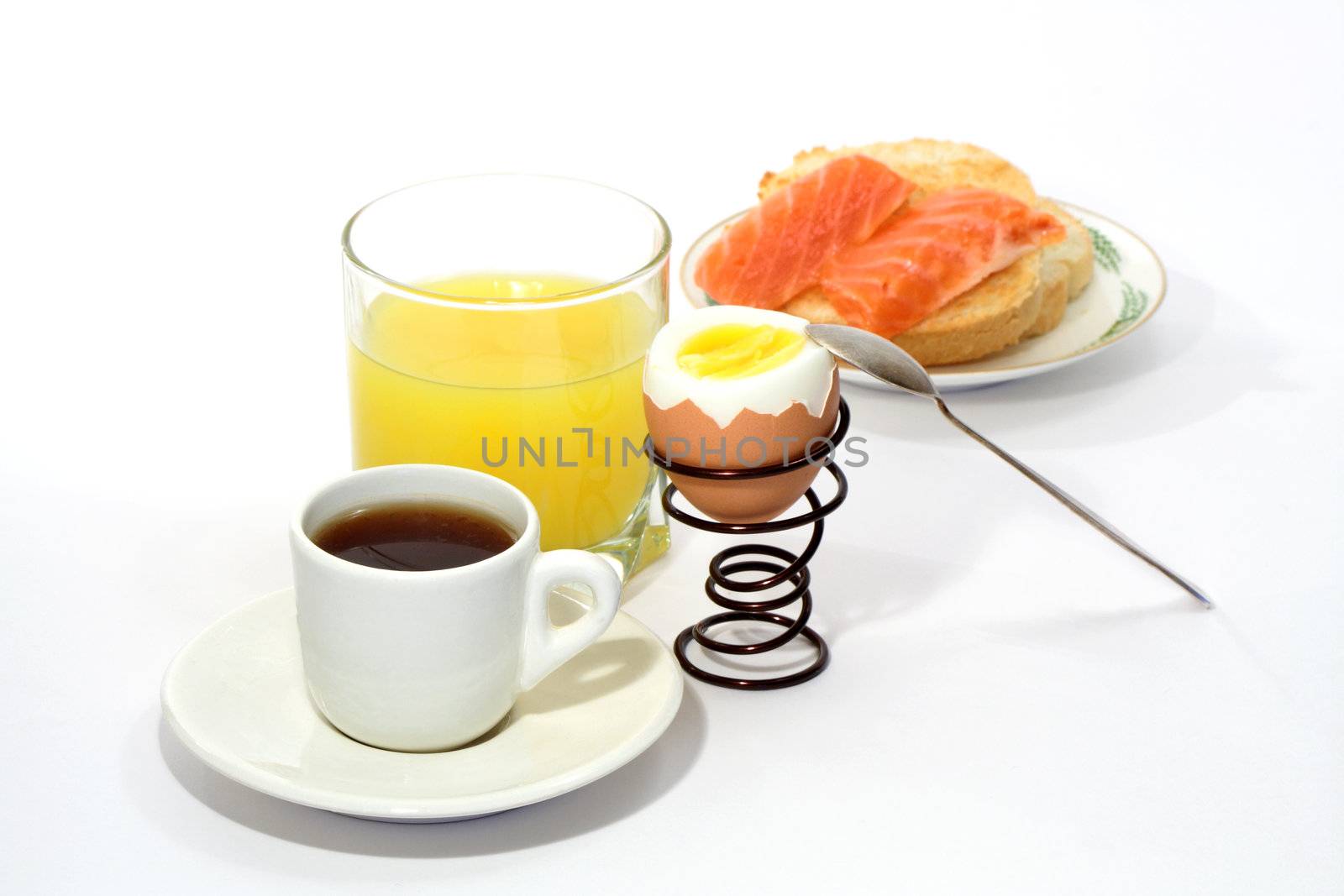 Still life with juice, coffee, boiled egg and fish sandwich isolated on white background