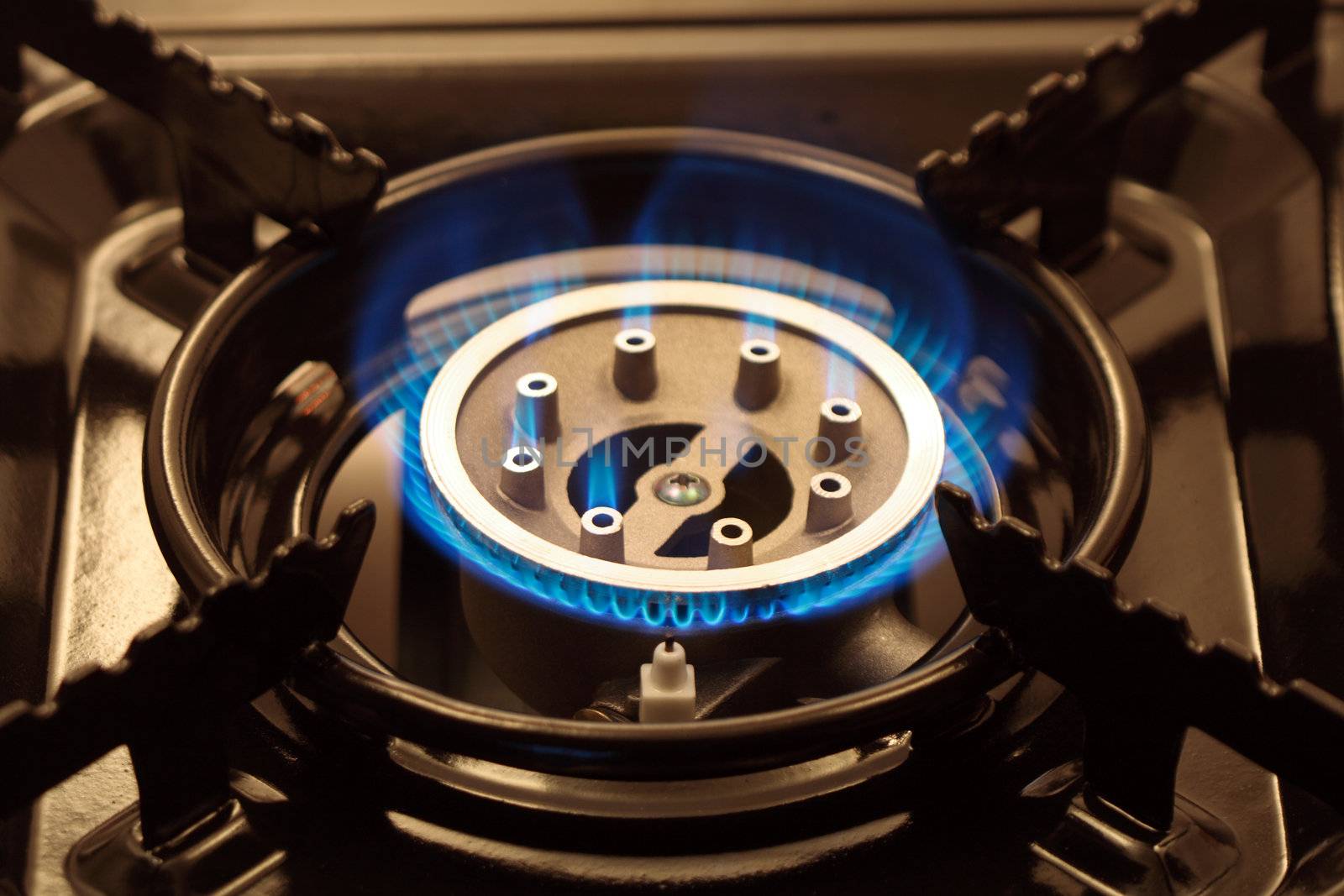 Closeup of black portable gas range with blue flame