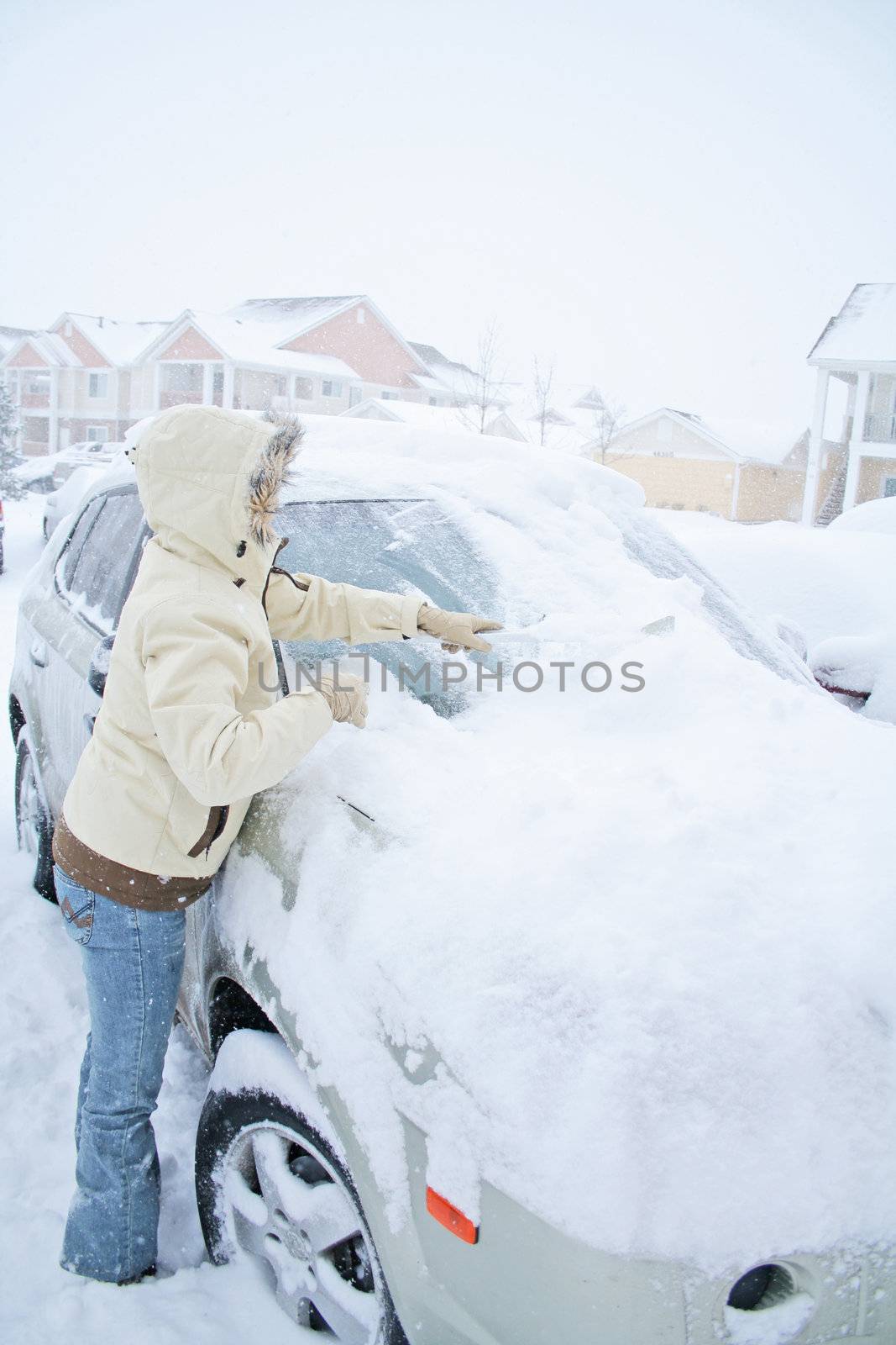Woman removing snow from windshield