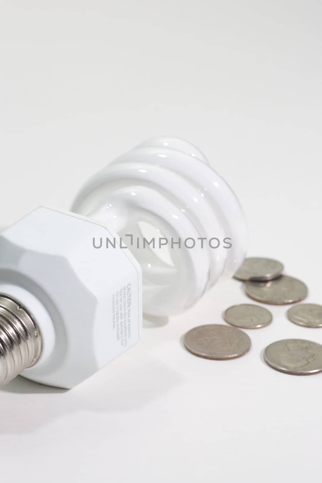 Compact Fluorescent bulb beside some american coins.