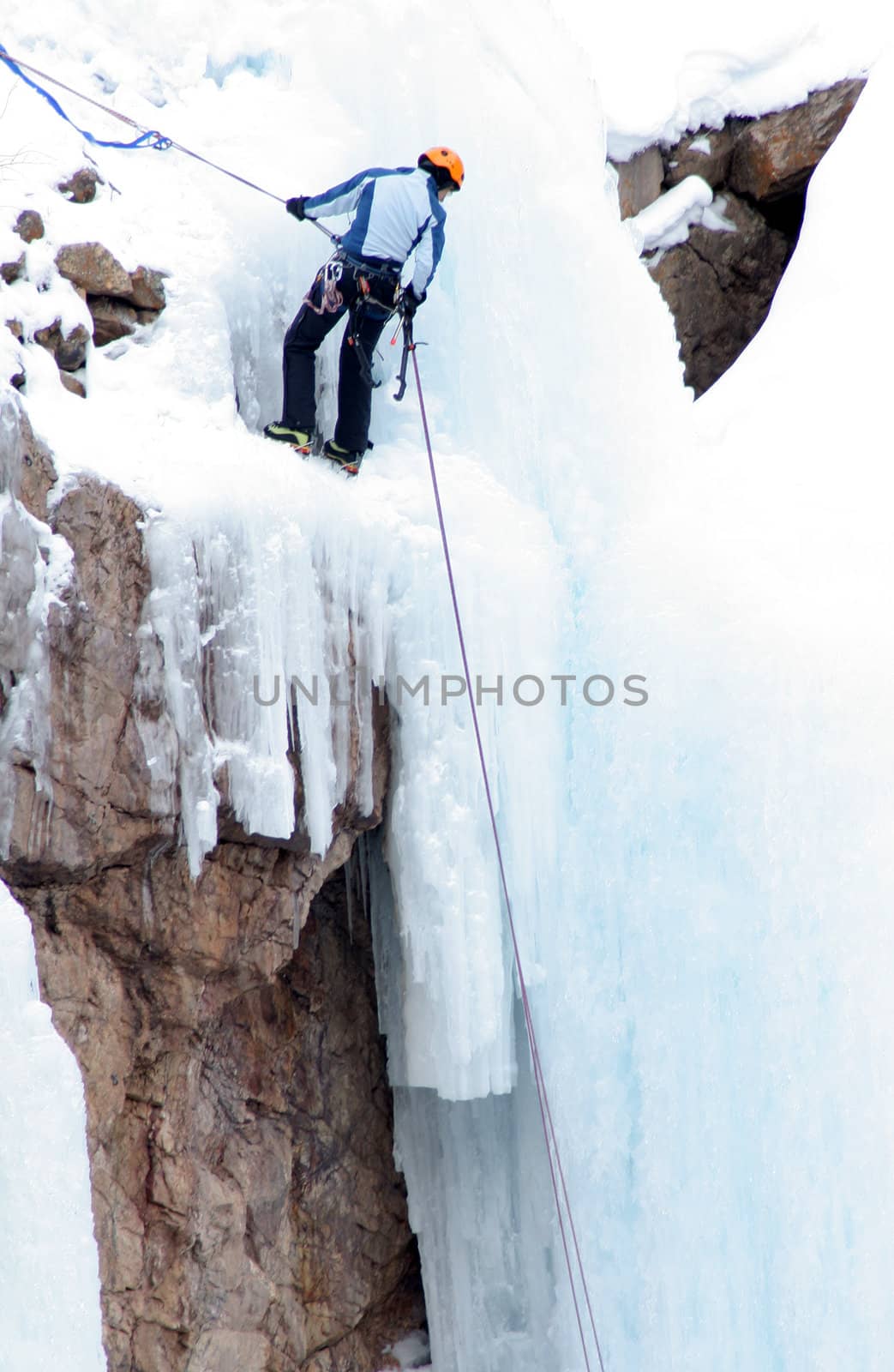 Man Ice Climbing Frozen Waterfall