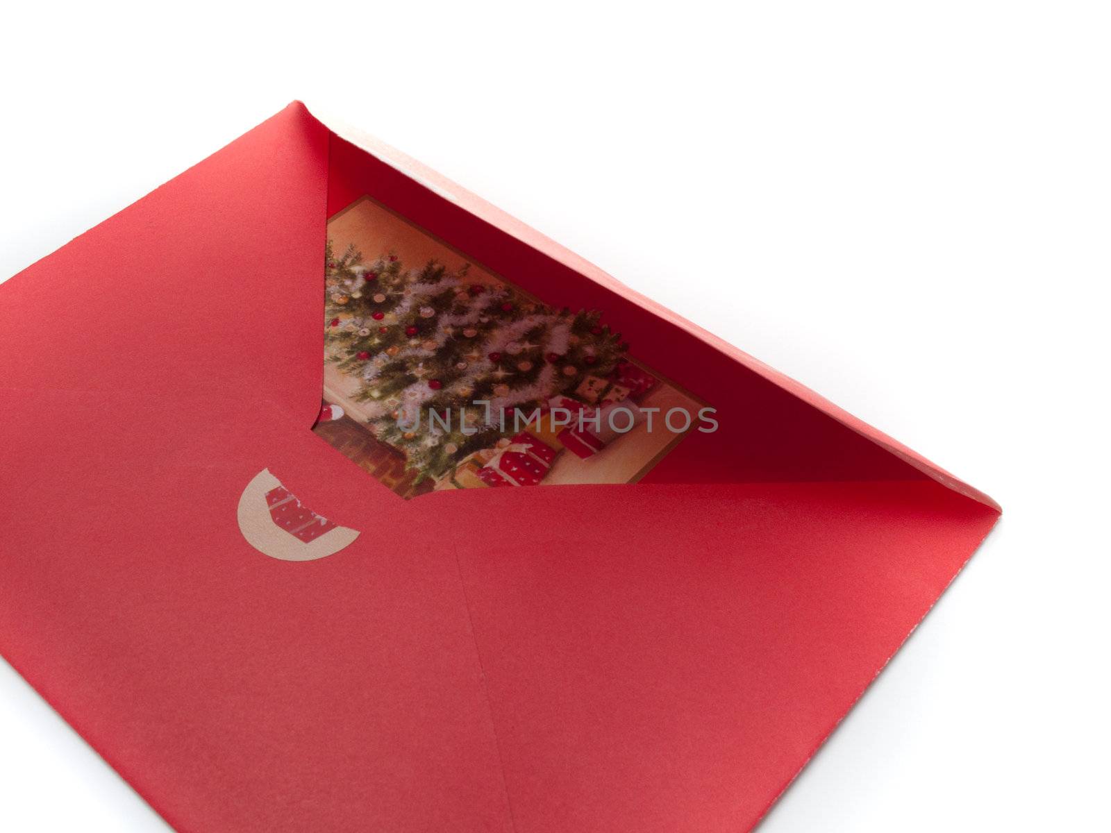 Closeup of a red christmas envelope with a card in it, isolated on white.