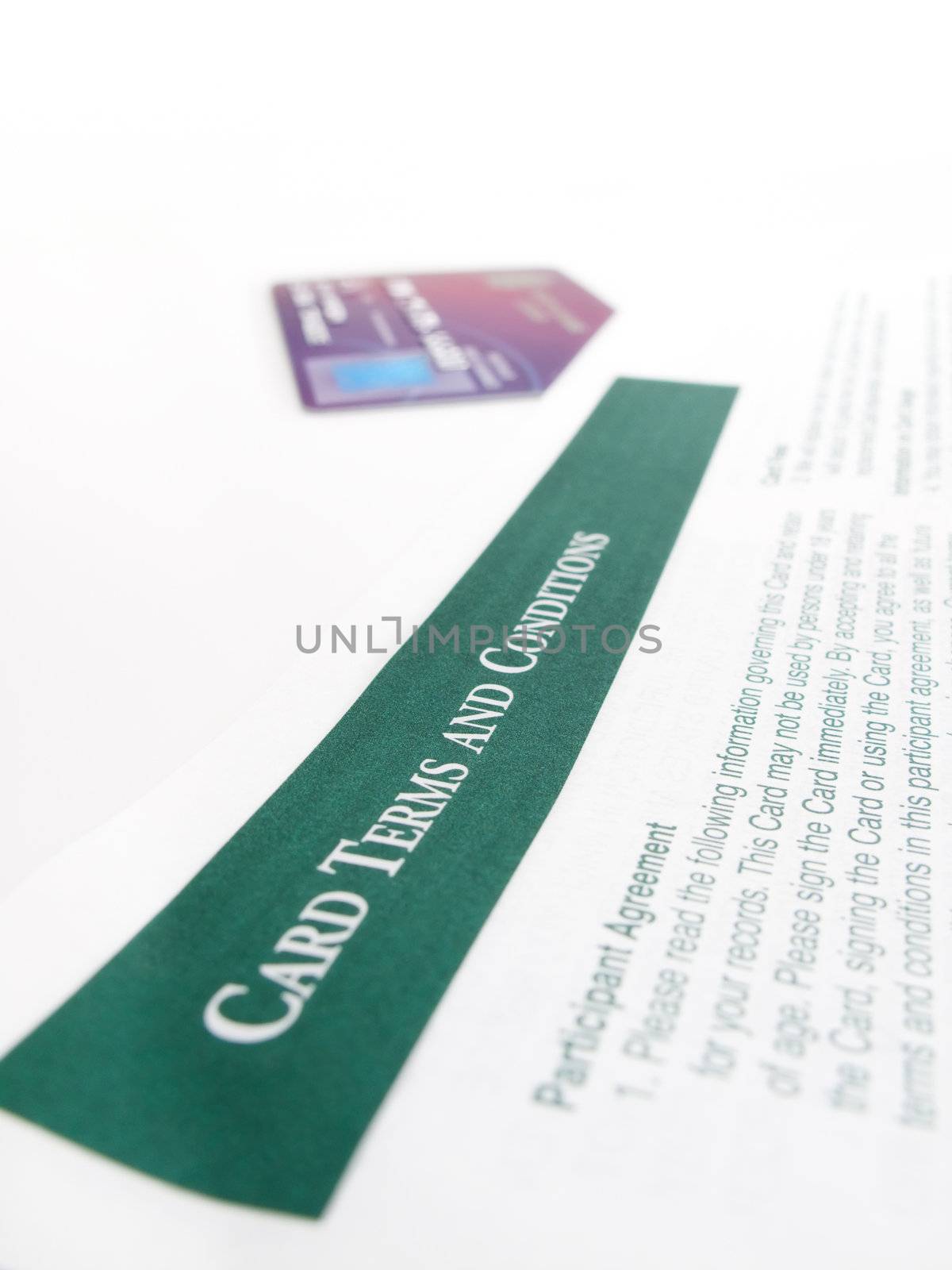 Credit card terms and conditions, with a credit card in the background.