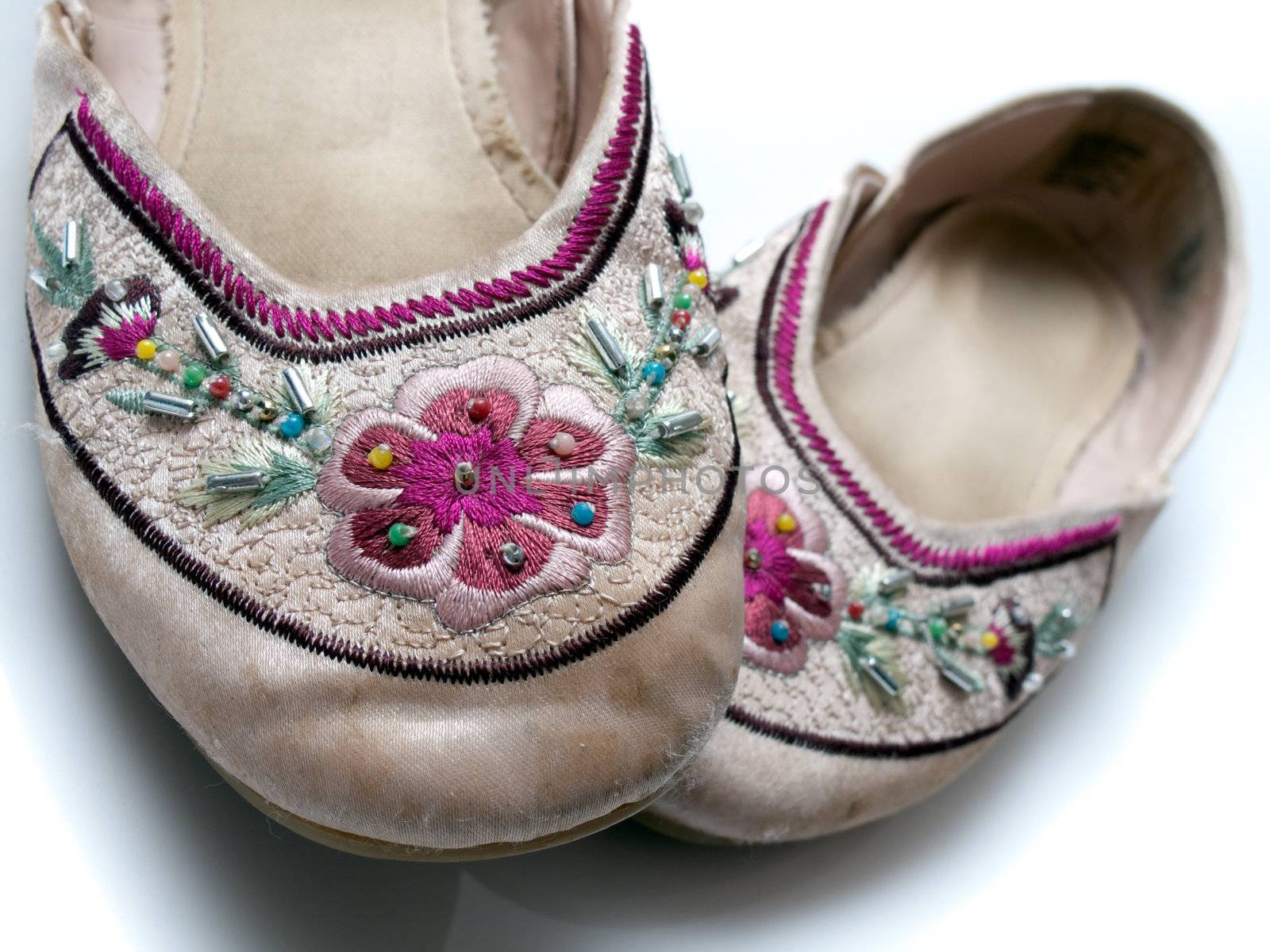 A set of woman / girl slippers, with some bead-work and stitching, isolated on white.