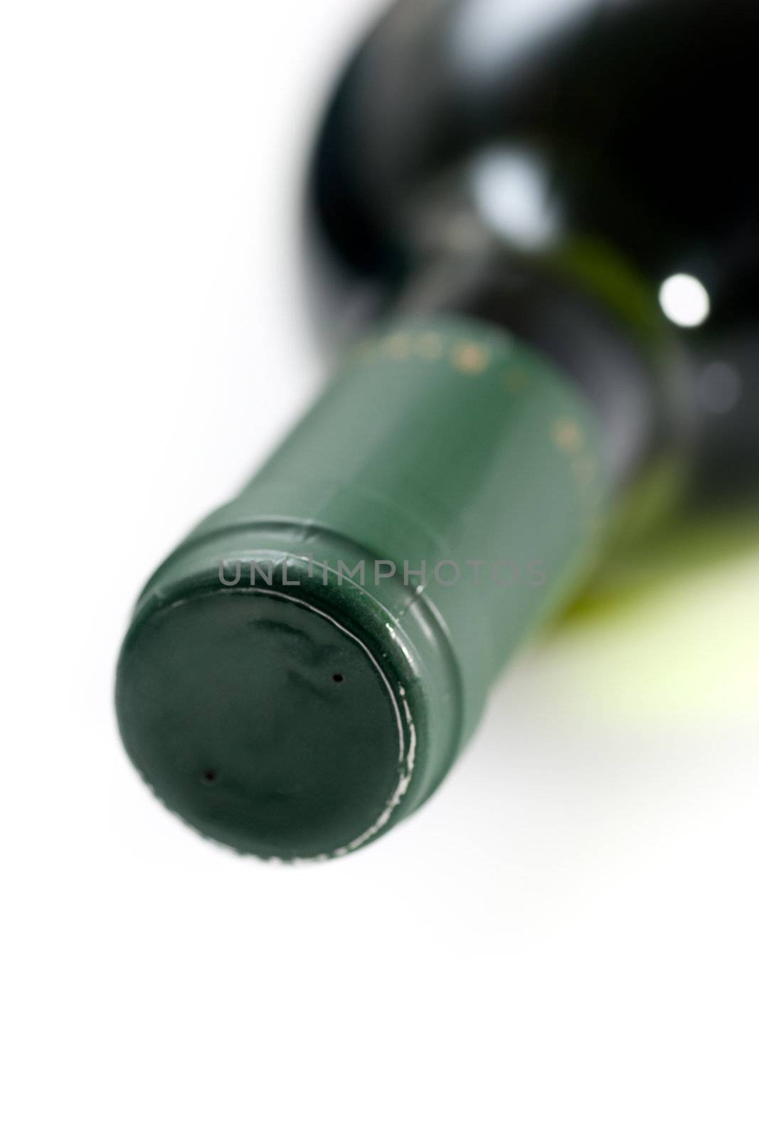 Closeup of the neck and spout of a wine bottle, lying on its side.
