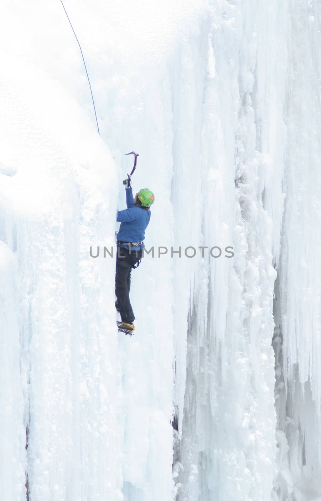 Man Ice Climbing Frozen Waterfall