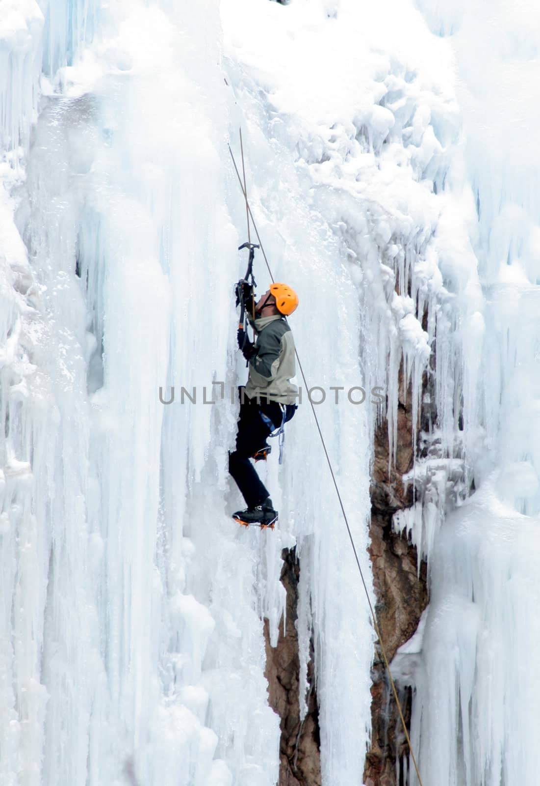 Man Ice Climbing Frozen Waterfall