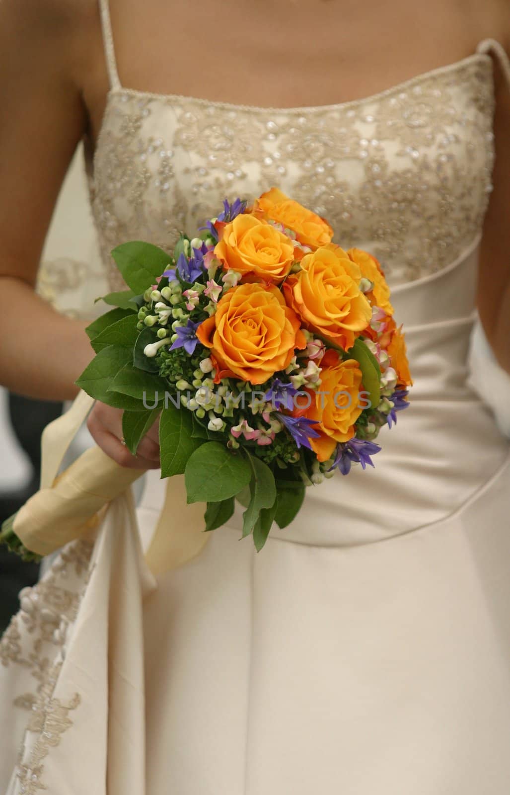 Wedding bouquet from yellow roses in hands of the bride