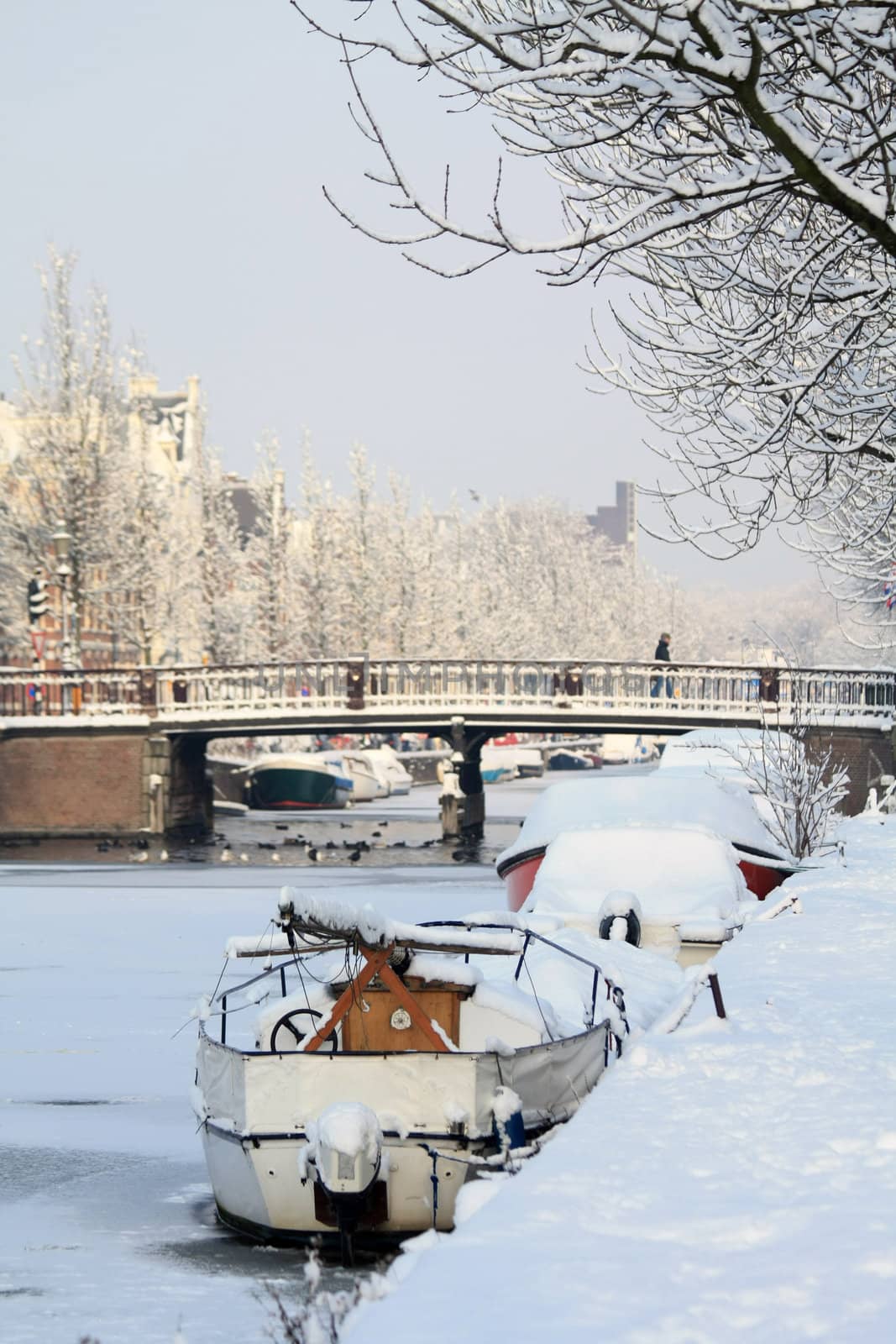 A frozen canal with snow coverd boats in Haarlem, Holland