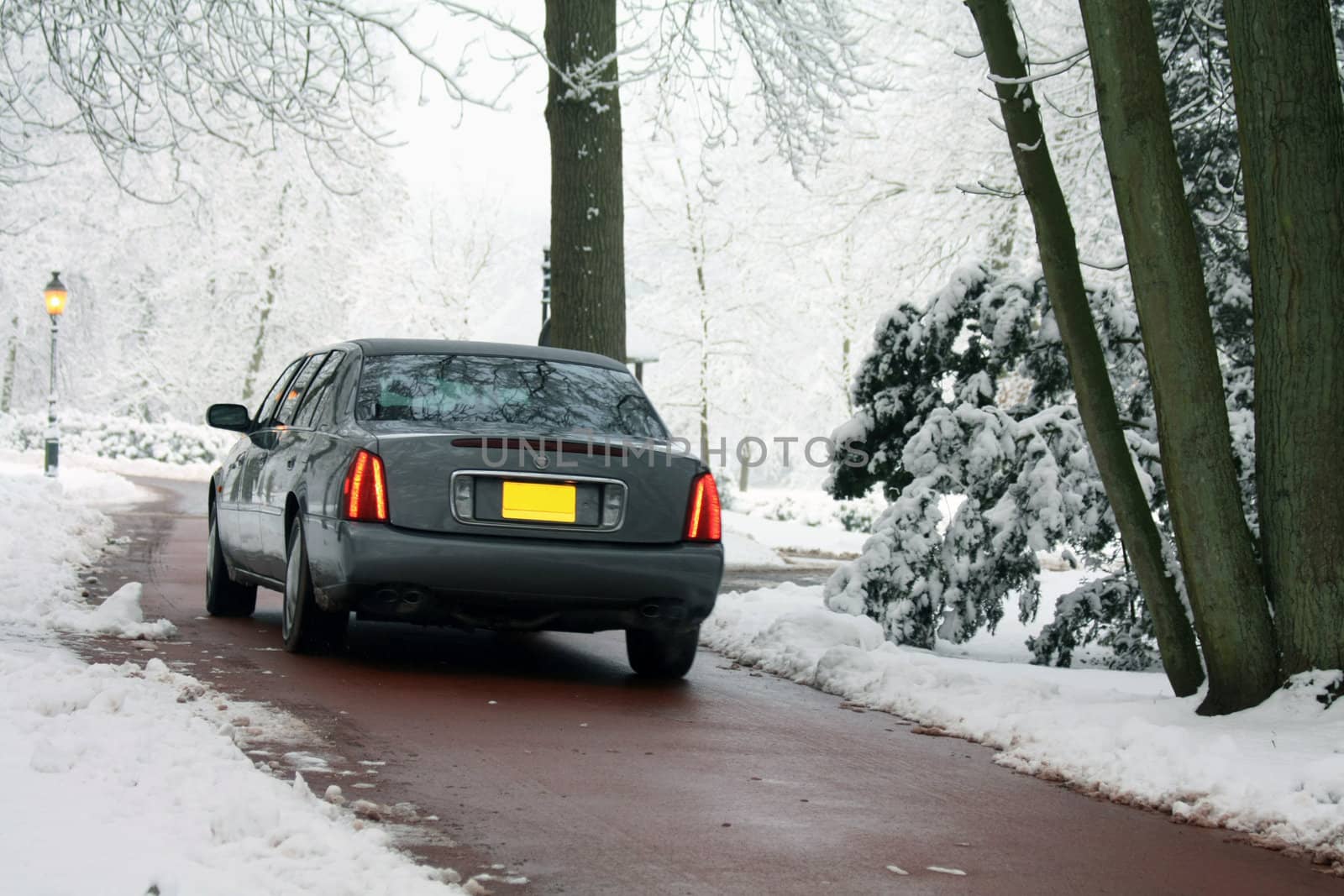 a grey streched limousine on a winter country road