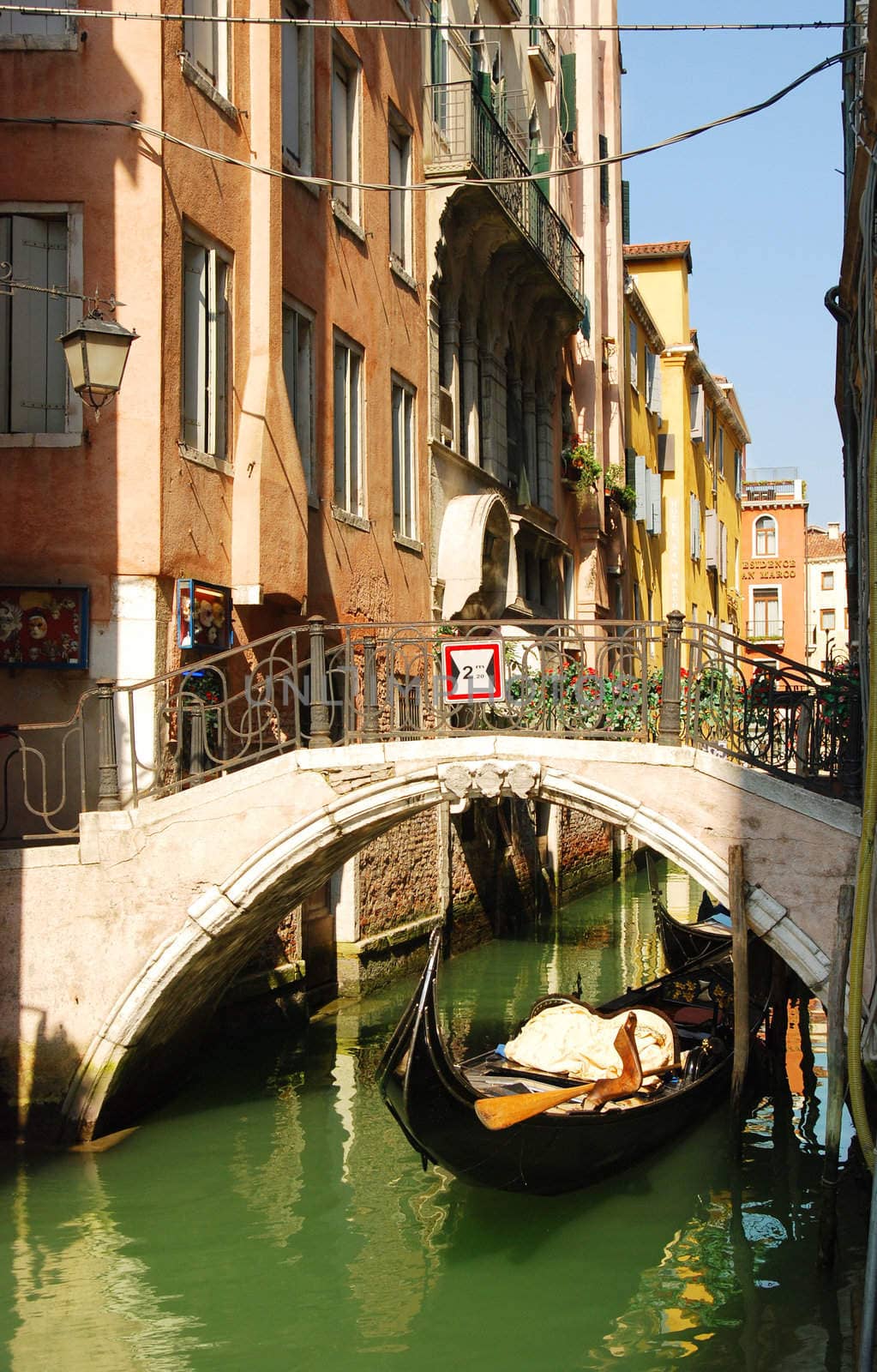 Gondola under bridge in venetian canal