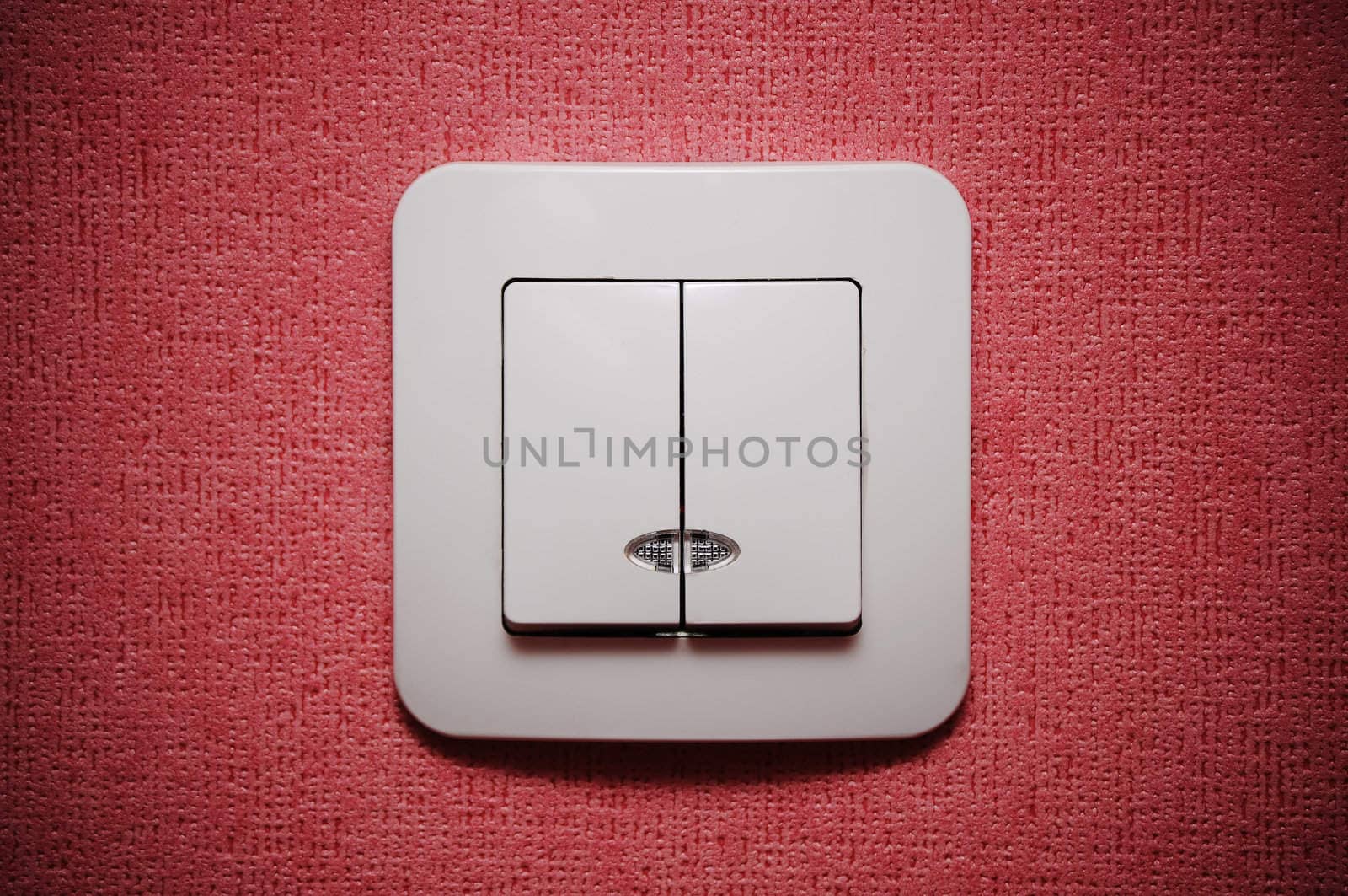 Double light switch against red wall closeup