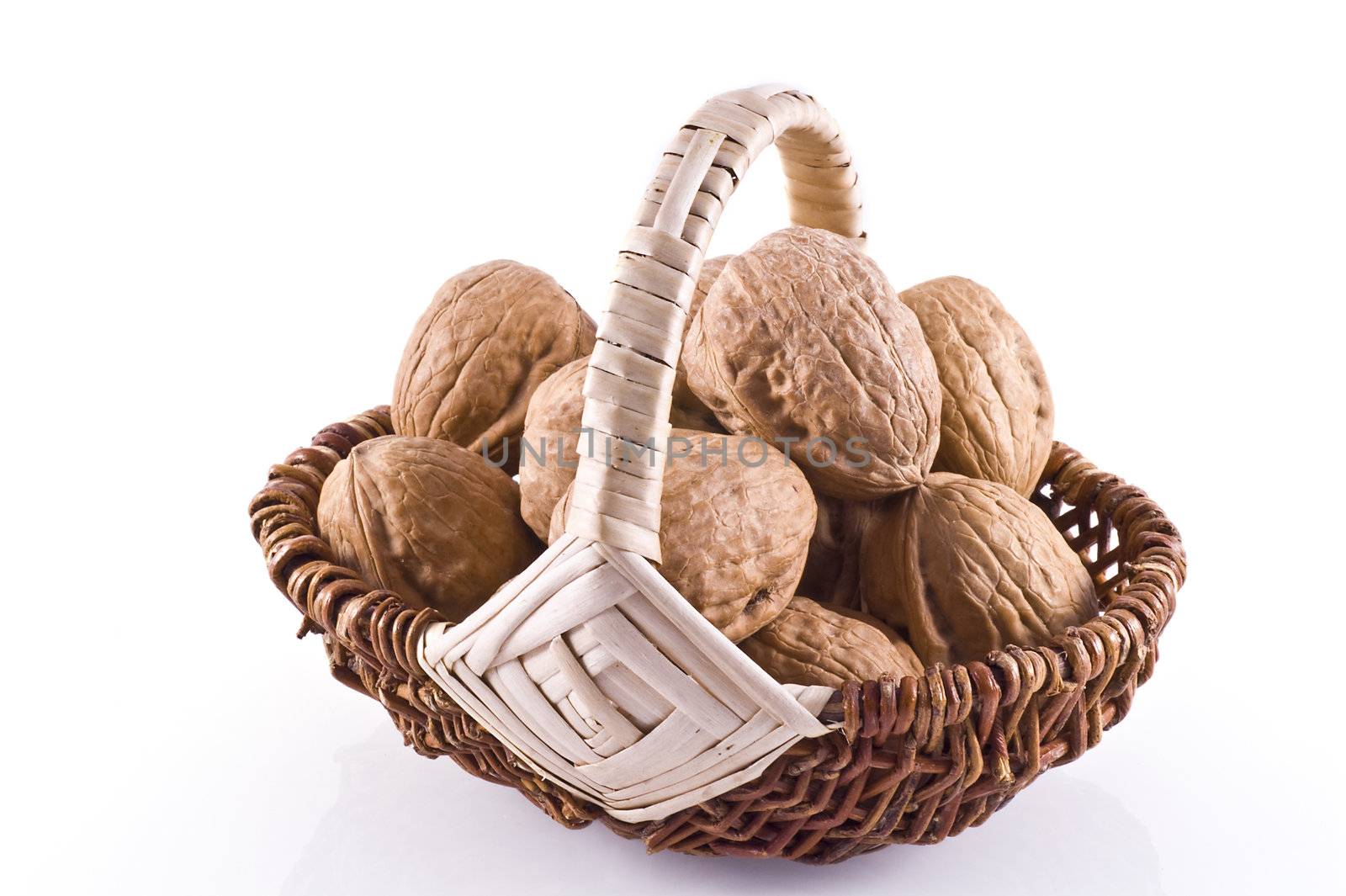 Basket filled with walnuts, isolated on white.