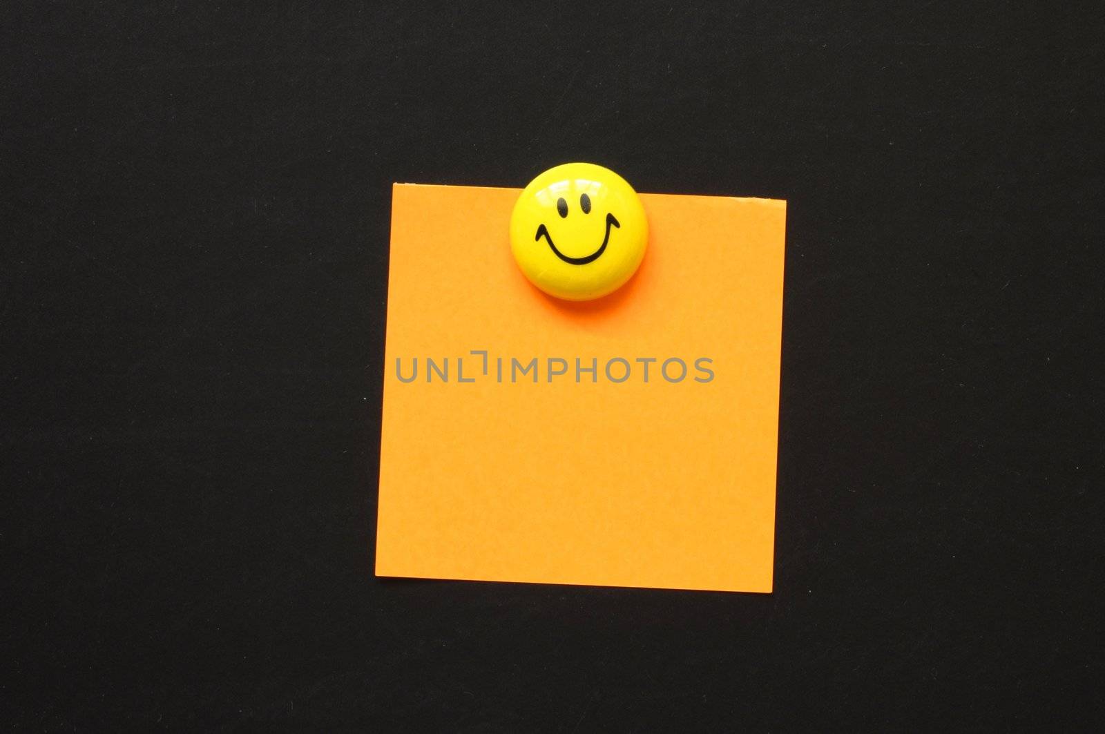 note paper on black blackboard or chalkboard with copyspace and smile