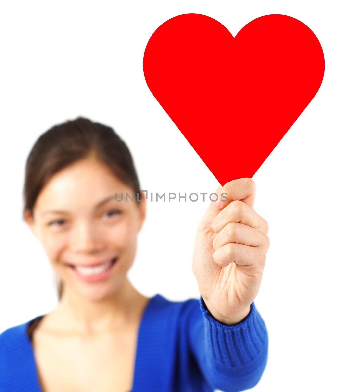 Cute woman in love holding a heart shape copy space to put your text in. Isolated on white background, focus on the heart sign.