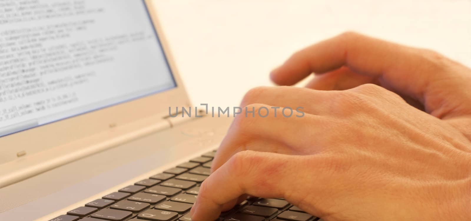 Hands typing on a laptops keyboard