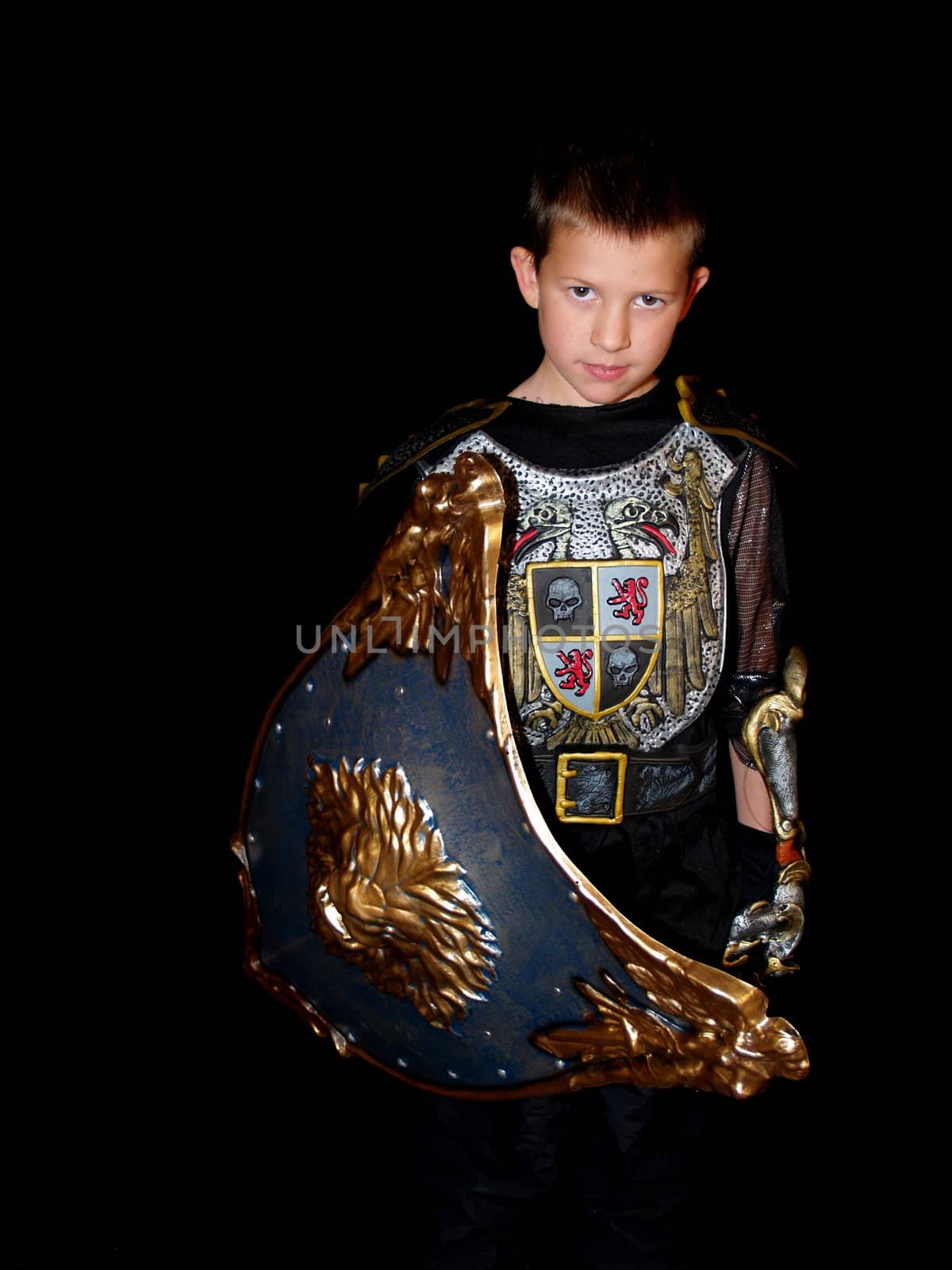 Little boy in a dark knight costume with a shield