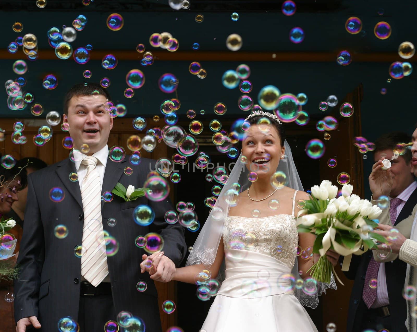 Happy newly-married couple on a background of soap bubbles