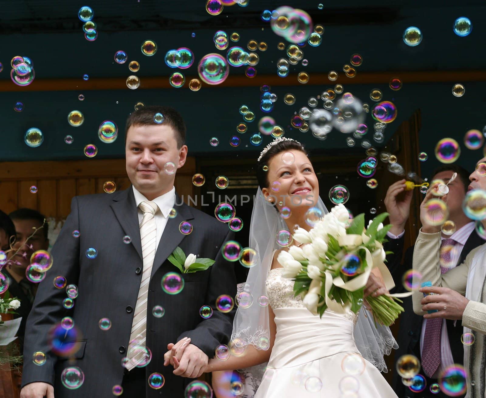Happy newly-married couple on a background of soap bubbles