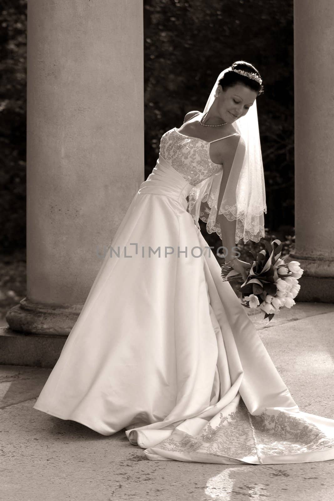Beautiful bride with bouquet in park. b/w+sepia