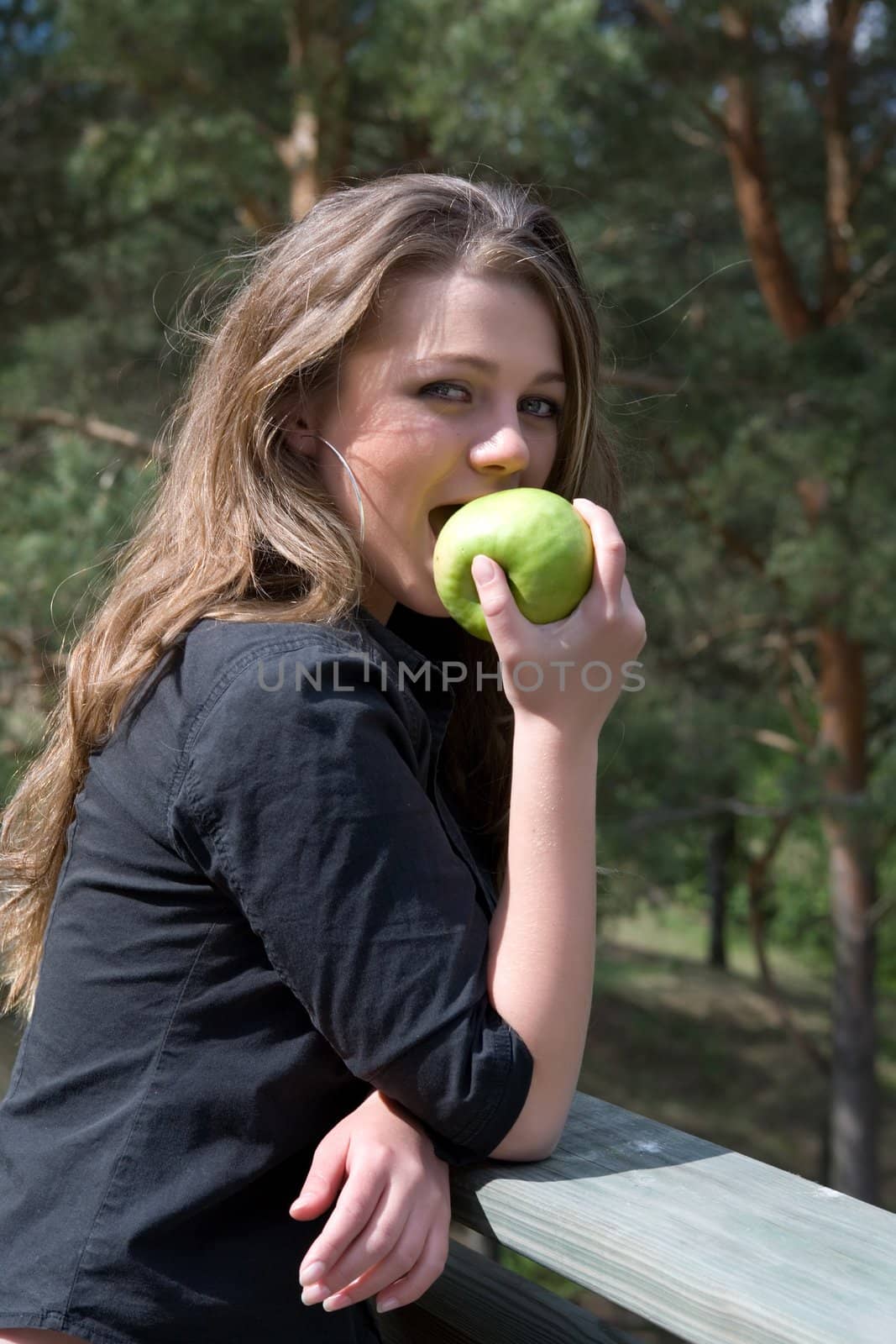 Young girl with apple on forest background