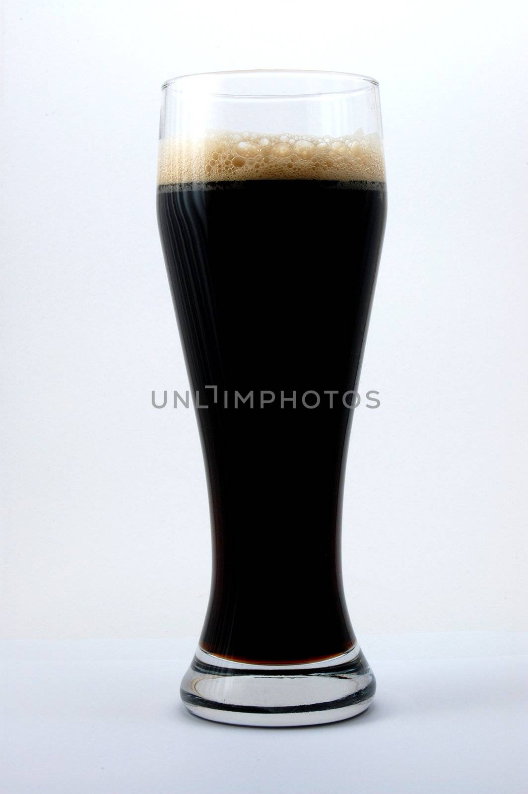 dark beer isolated on white background with foam