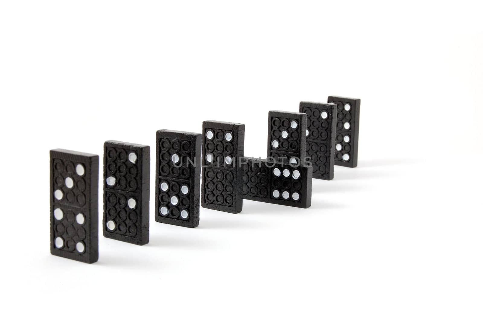 row of dominoes including a special domino stone isolated on white background