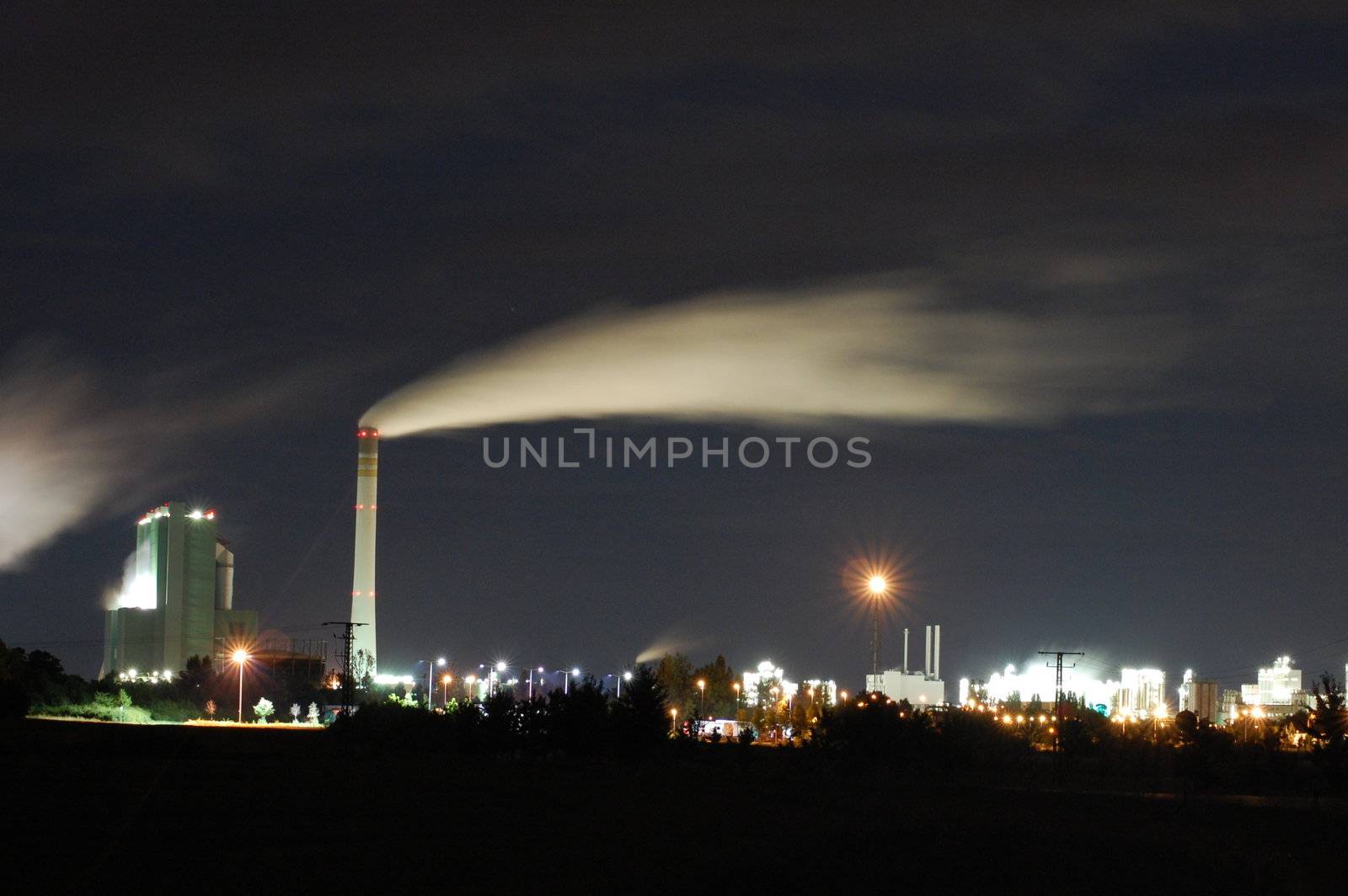 a smoking industrial power plant at night