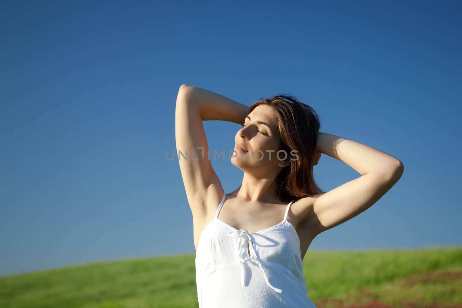 Beautiful young woman relaxing on the field