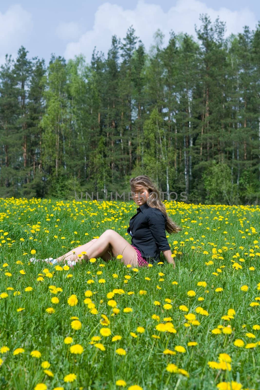  Young girl in short skirt on dandelion field