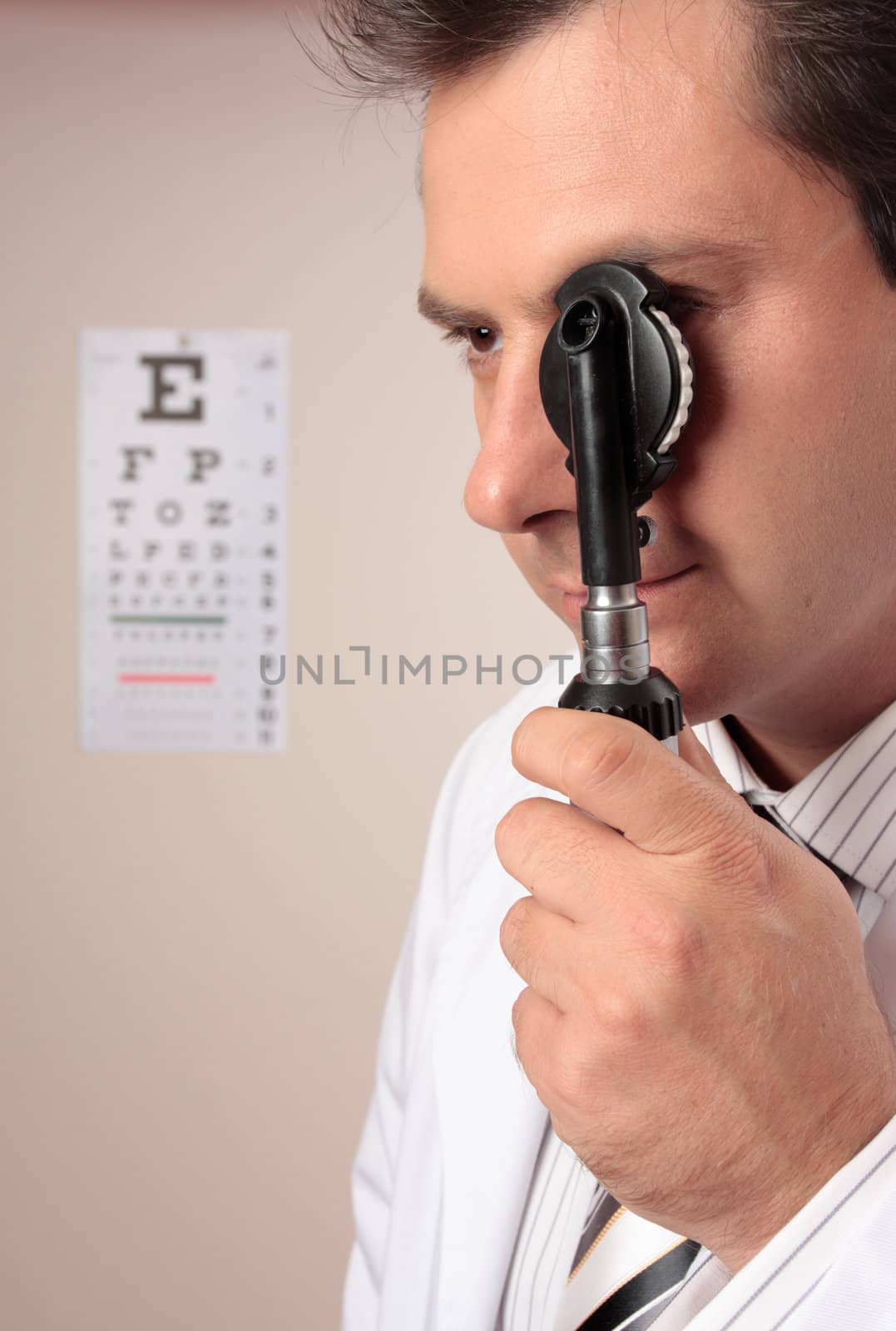 An eye doctor using an opthalmoscope device during an eyesight examination.