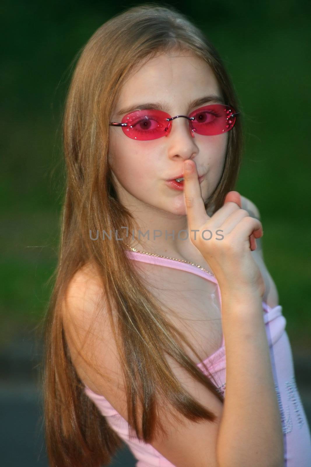 young girl making the silence sign, keep the secret
