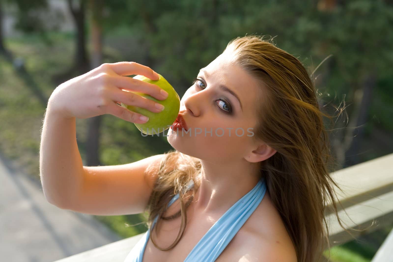 Girl with apple on sunset