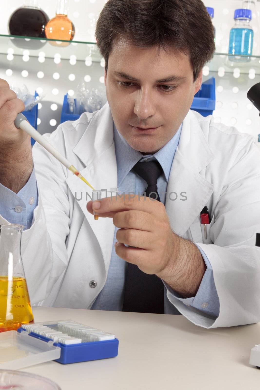 A scientific researcher dispensing liquid from a pipette into a microcentrifuge tube.