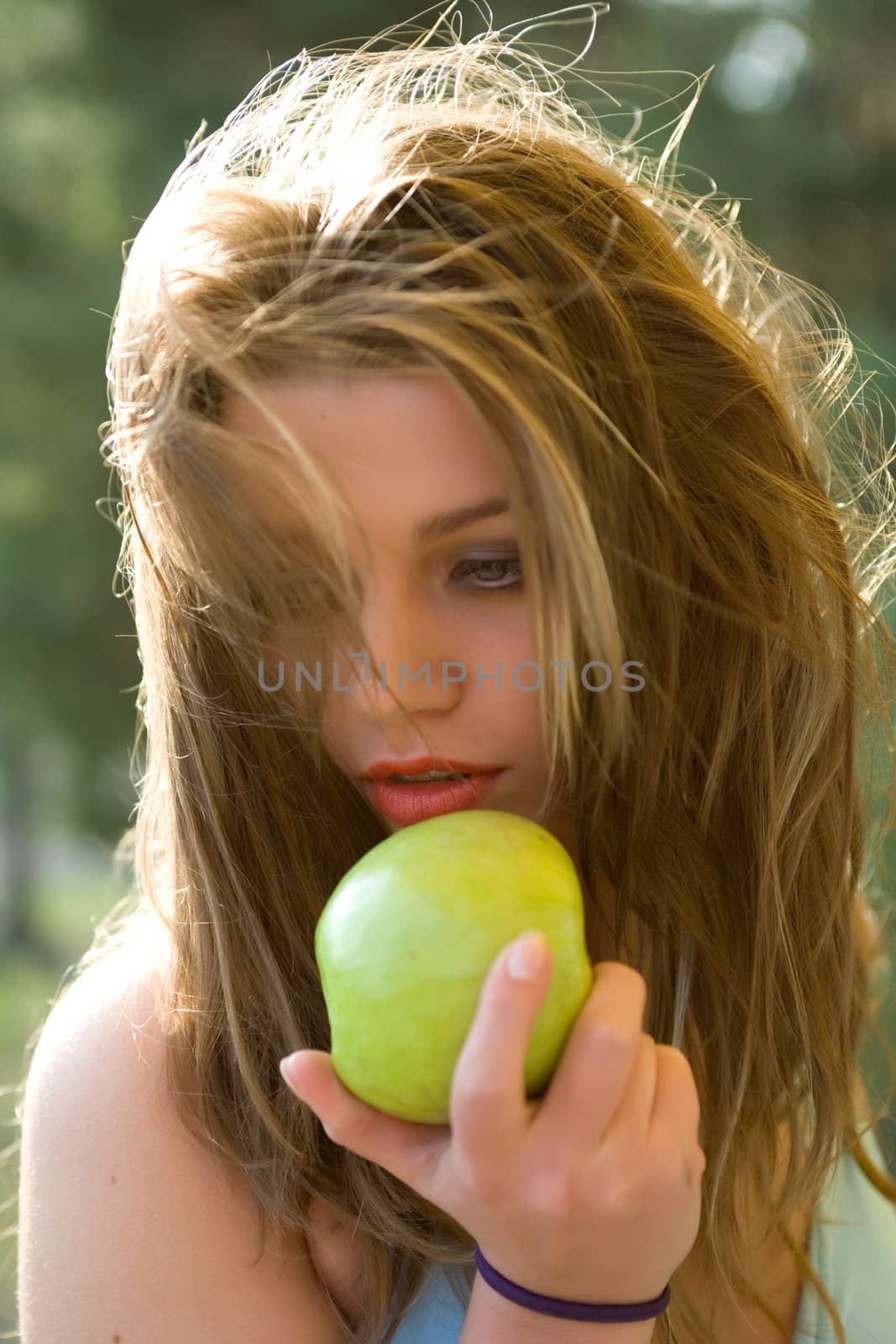 Girl with apple on sunset