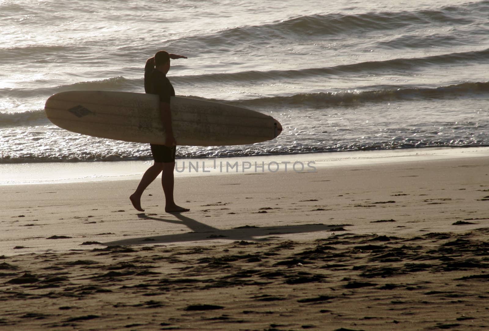 Early Morning Surf Check - Male Surfer Looking At The Ocean From The Beach