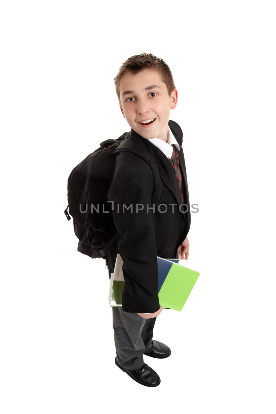 High school student carrying school bag backpack and text books.  He is in uniform, standing sideways and looking around .