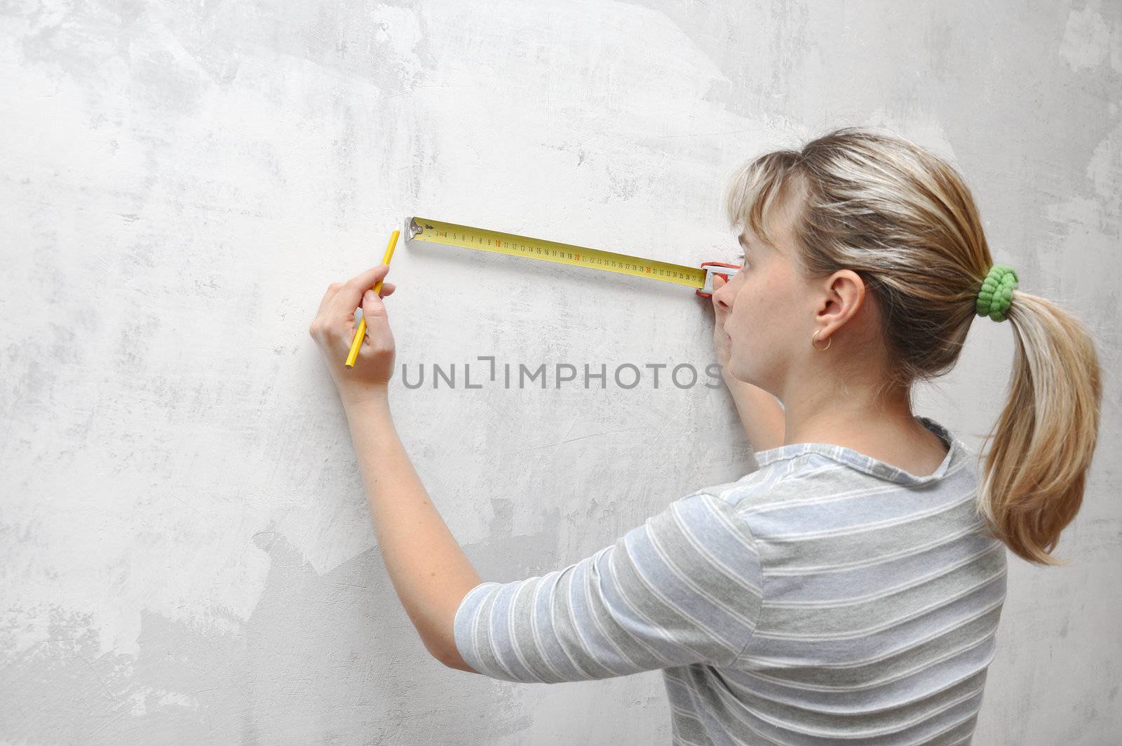 worker woman measuring on wall straightedgetape measure