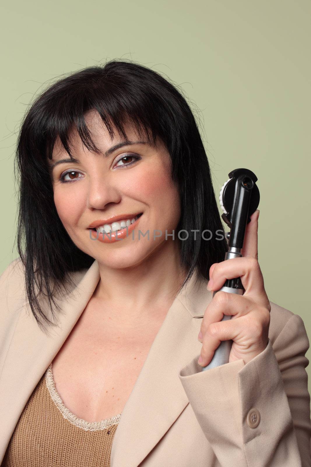 An optometrist or doctor holds an opthalmoscope eady to check eyes.