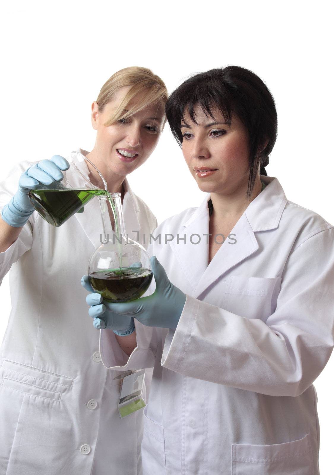 People, pouring liquid from a beaker into a round flat bottom flask.