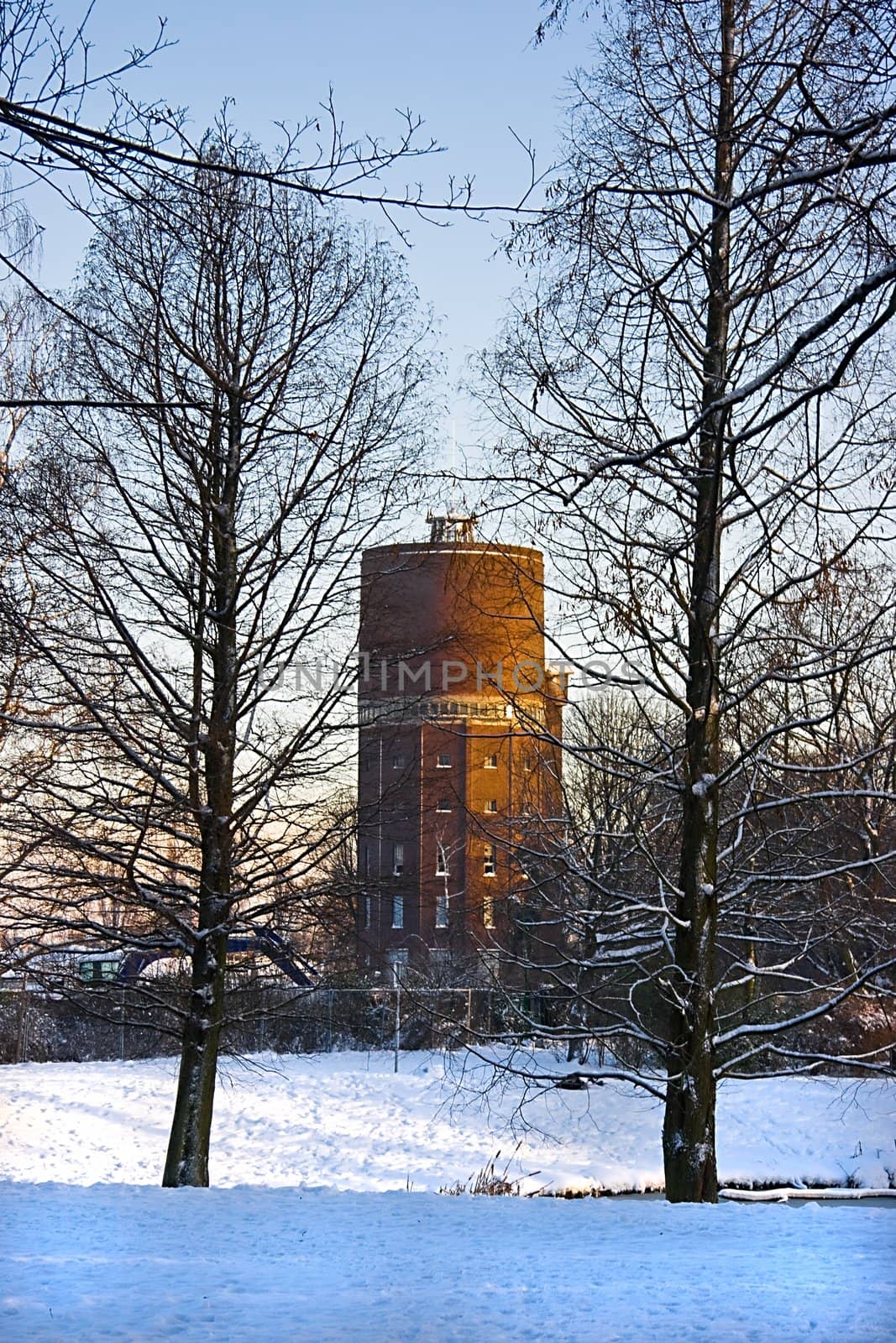 Old watertower with snow in winter  by Colette